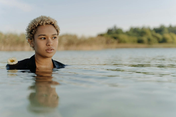 Woman with curly hair in water illustrating hair porosity