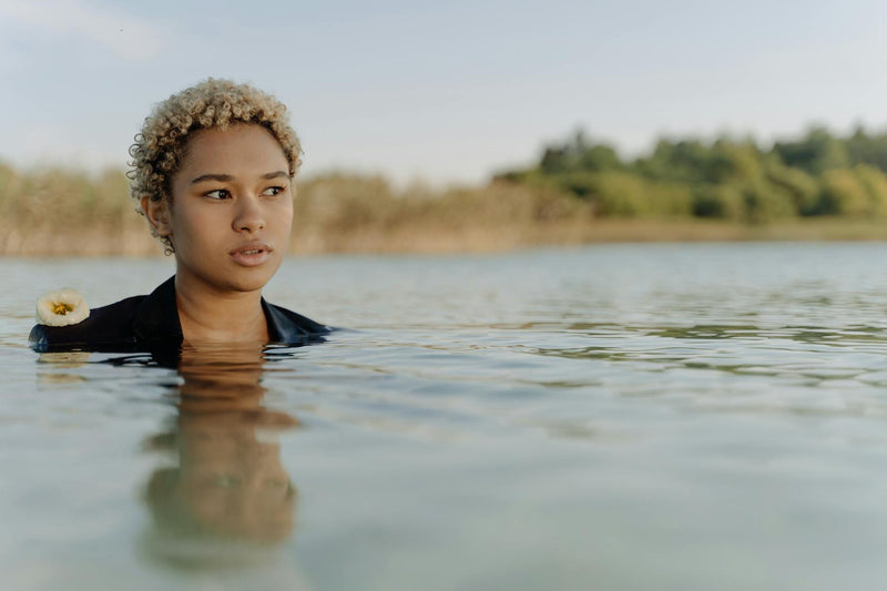 Woman with curly hair in water illustrating hair porosity
