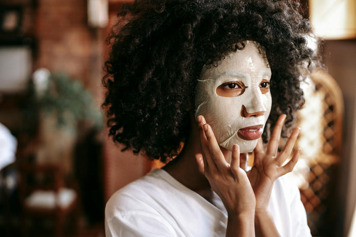Woman applying moisturising treatment to her curly hair
