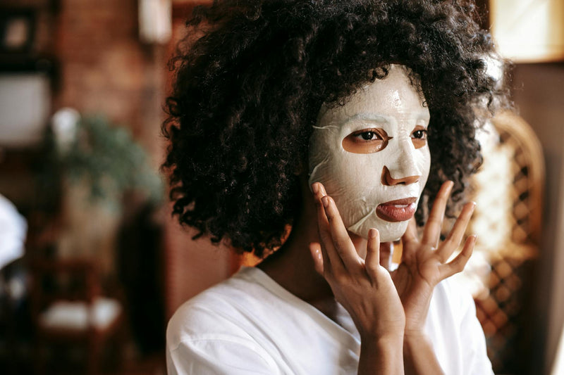 Woman applying moisturising treatment to her curly hair