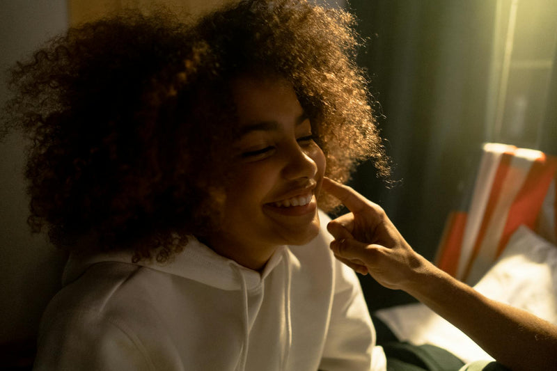Woman with refreshed second-day curly hair smiling