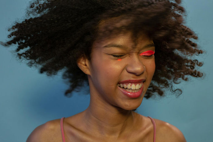 Woman with glossy moisturised curly afro hair