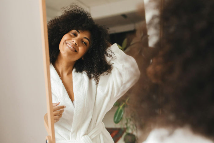 Woman with curly hair following her hair care routine at home